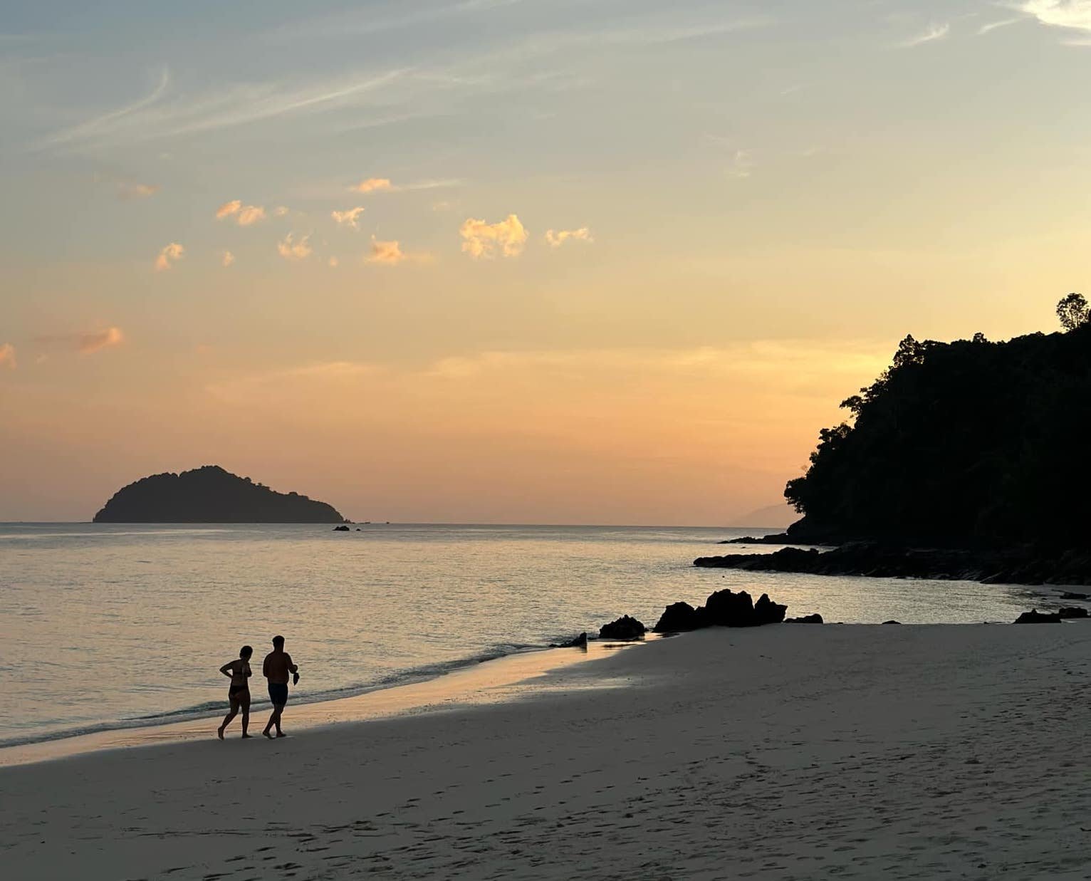 Guests walking along the beach at sunset on Koh Bulon-Lae